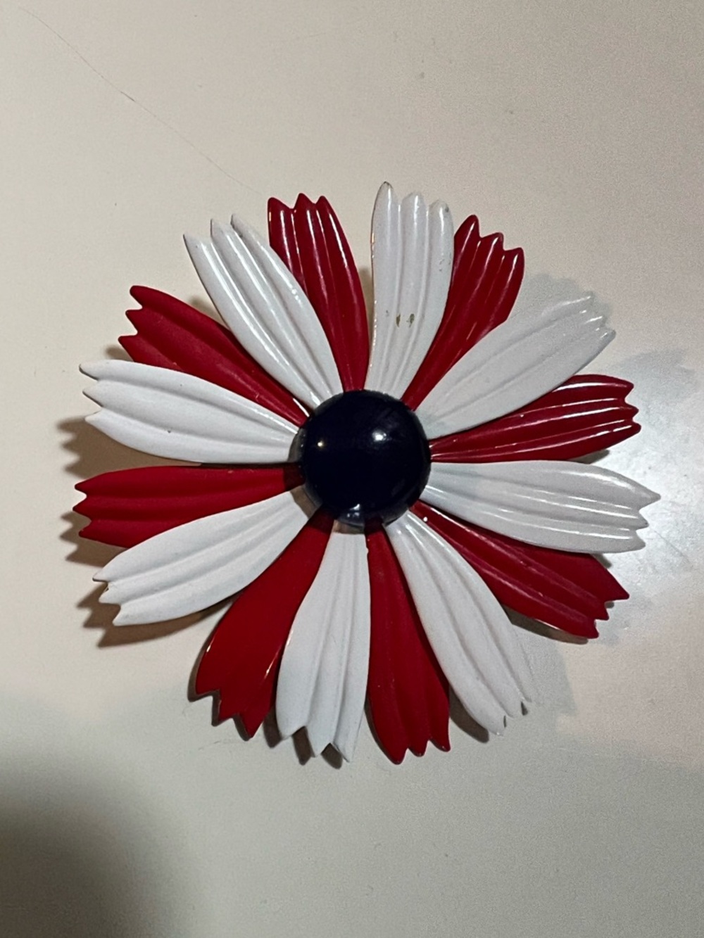 1960s enamel patriotic brooch with red and white petals and blue dome center.